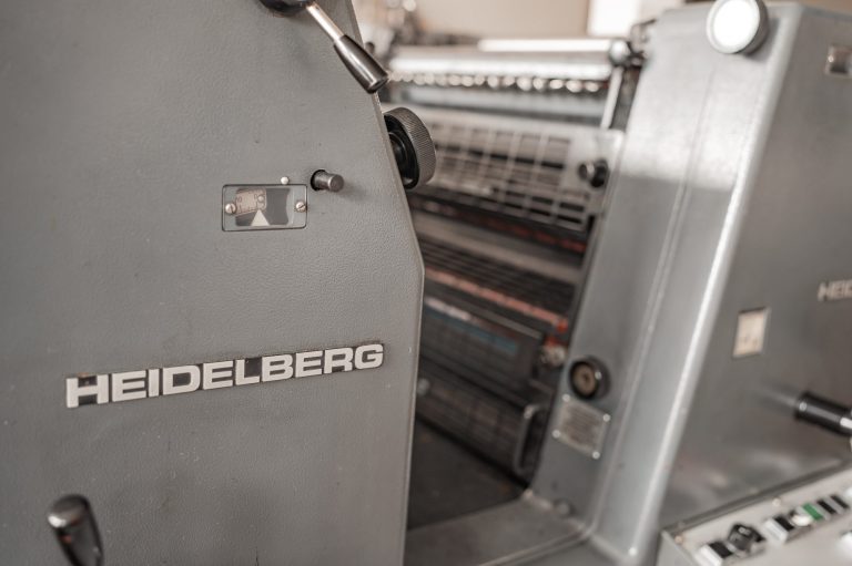 Details einer Heidelberg-Druckmaschine mit metallischen Oberflächen und Bedienelementen.
