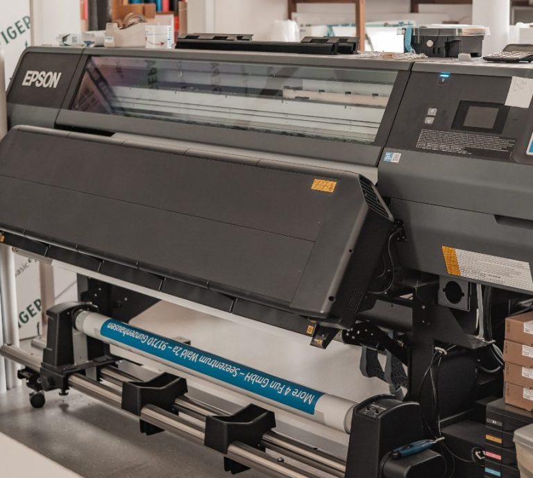 Großfornmatdrucker in einem Raum mit verschiedenen Materialien und Farbmusterwänden.