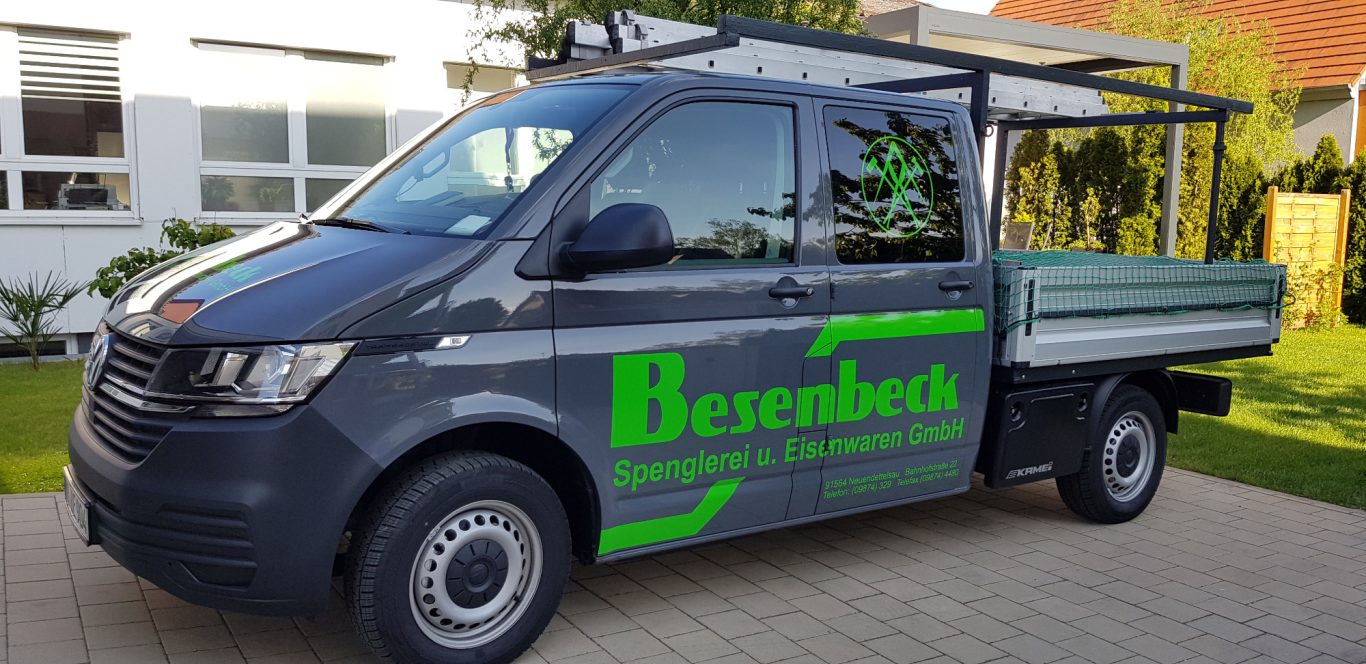 Grauer Transporter mit grüner Beschriftung "Berenbruch" auf einem gepflasterten Parkplatz.